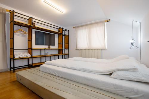 a white bedroom with a large bed and a tv at MOBstar in Alba Iulia