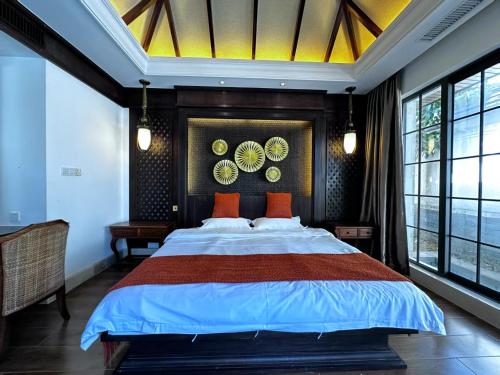a bedroom with a large bed in a room with windows at Perfume Bay Tianhai Meiya B&B in Lingshui