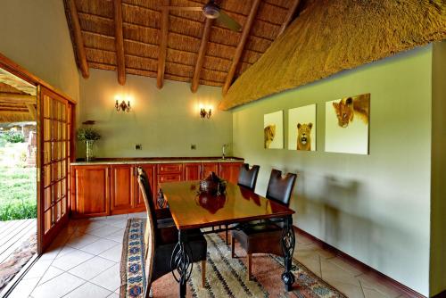 a dining room with a wooden table and chairs at Royal Morubisi Founder's Lodge in Kaingo Private Game Reserve