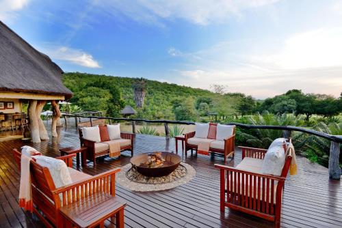 a deck with chairs and a fire pit on it at Royal Morubisi Founder's Lodge in Kaingo Private Game Reserve