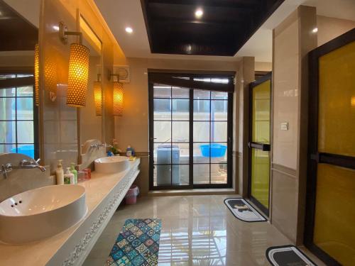 a bathroom with two sinks and a large window at Perfume Bay Tianhai Meiya B&B in Lingshui