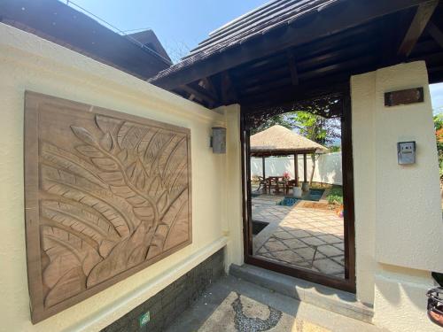 a house with a door with a tree etched into it at Perfume Bay Tianhai Meiya B&B in Lingshui