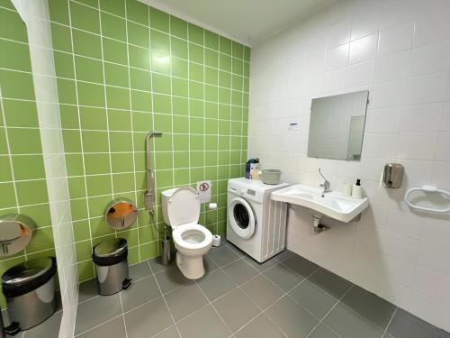 a bathroom with a toilet and a sink and a washing machine at Refúgio Rural Ponte de Lima - Vista Verde e Tranquilidade in Ponte de Lima