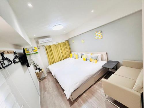 a bedroom with a white bed and a couch at ying-Shinjuku hostel in Tokyo
