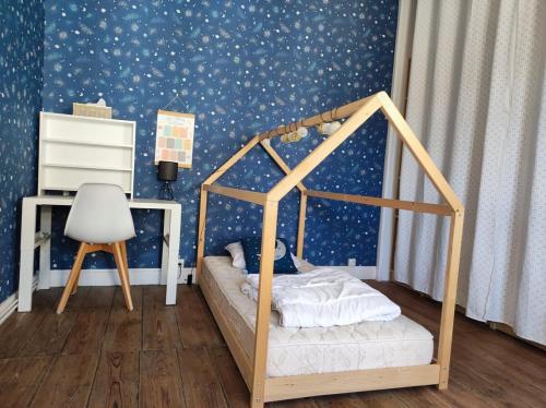 une chambre avec un lit à baldaquin dans une pièce avec du papier peint étoilé dans l'établissement Maison de ville au calme, à Cognac