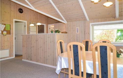 a dining room with a table and chairs at Holiday Home Fyrrelunden Oksbøl in Oksbøl