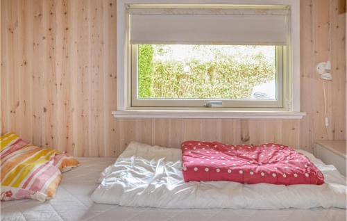 a bed in a room with a window at Holiday Home Fyrrelunden Oksbøl in Oksbøl