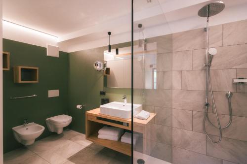 a bathroom with a shower and a sink and a toilet at Archehof Hochzirm Lodge Anna in Campo Tures