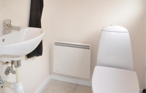 a bathroom with a toilet and a sink at Holiday Home Fyrrelunden Oksbøl in Oksbøl