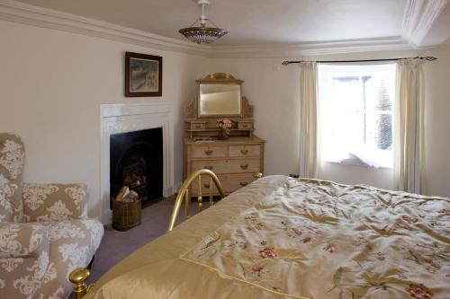 a bedroom with a bed and a fireplace and a mirror at Cosy Cottages in Masham in Masham