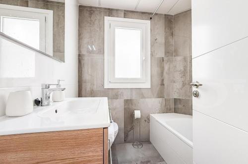 a bathroom with a sink and a toilet and a window at Chic Gem Rooftop terrace with BBQ REMS in Fuengirola