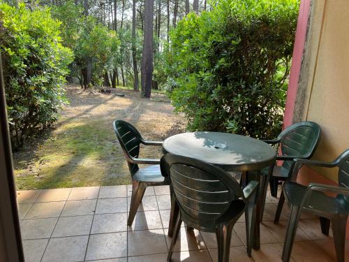 a table and chairs sitting on a porch at L'orée des Pins TROPICO Appartement T2 en RDC avec terrasse refait à neuf in Lacanau