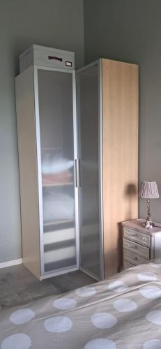 a refrigerator in a bedroom with a lamp and a dresser at Homeliday RELAX in Caldana
