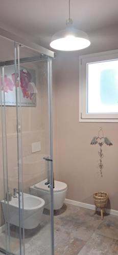a bathroom with a toilet and a glass shower at Homeliday RELAX in Caldana