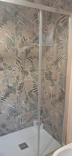 a shower in a bathroom with a wall at Homeliday RELAX in Caldana