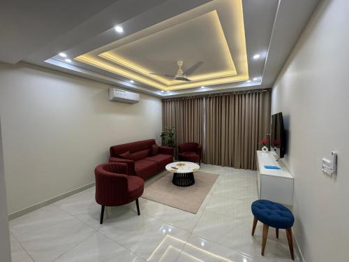 a living room with a couch and a tv and chairs at Premium Pavilion in Islamabad