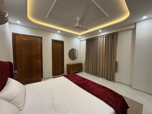 a bedroom with a large bed with a ceiling at Premium Pavilion in Islamabad