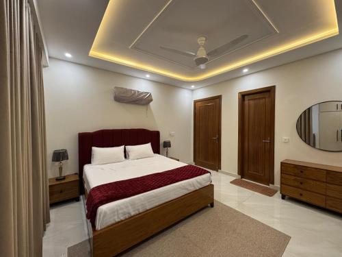 a bedroom with a large bed and a mirror at Premium Pavilion in Islamabad