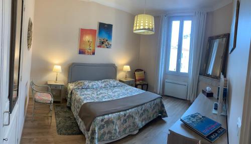 une chambre avec un lit, une table et une fenêtre dans l'établissement 2 pièces cannes centre, à Cannes