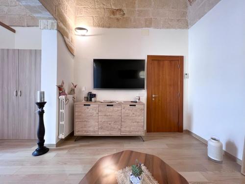 a living room with a flat screen tv on a wall at Suite MariaGiulia Monopoli in Monopoli
