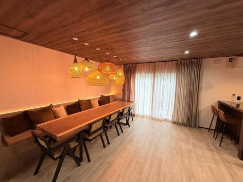 a dining room with a long wooden table and chairs at 興津ビーチサイドヴィラ 勝浦 - Okitsu Beachside Villa - Katsuura in Katsuura