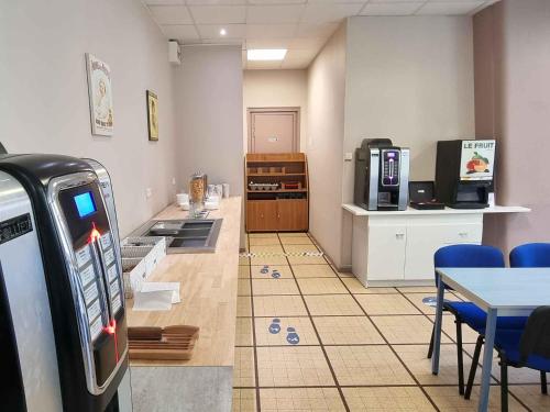 a room with a gas station with a table and chairs at Auberge de Jeunesse - HI Verdun in Verdun