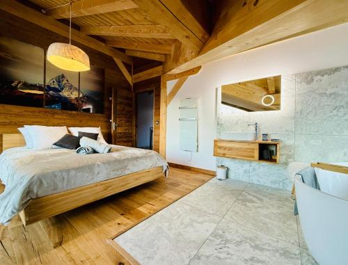 une chambre avec un lit et une salle de bain avec un lavabo dans l'établissement Chalet Monarch - Les Carroz - Sauna, Spa & vue Montagnes, à Arâches-la-Frasse