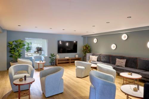 a living room with a couch and chairs and tables at Wyndham Athens Residence in Athens