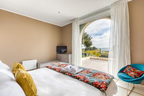 une chambre avec un lit et une grande fenêtre dans l'établissement Villa Domaine du Soleil, Vue Mer avec piscine, au Lavandou