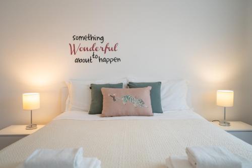 a bedroom with a large white bed with two lamps at Hapton house Central 12 in Mestre