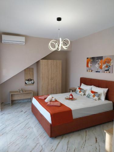 a bedroom with a large bed and a chandelier at Villa Atspas studios in Skala Marion