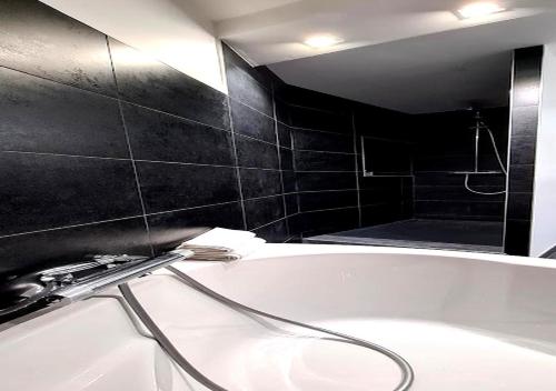 La salle de bains est pourvue d'une baignoire et d'un lavabo. dans l'établissement Le 39 Dole Appartement industriel au cœur de Dole, à Dole