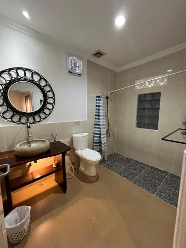 a bathroom with a toilet and a sink and a mirror at Villa Padi Cangkringan in Sleman