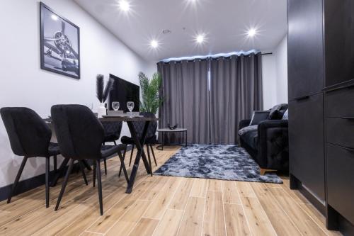 a living room with a table and chairs and a couch at Brand-New Borehamwood 1-Bed, 1-Bath Flat in Borehamwood