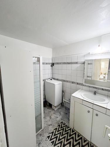 a white bathroom with a sink and a toilet at Villa plaisir de vivre in Petit-Bourg