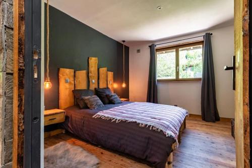 a bedroom with a large bed and a window at Villa - Détente & Jacuzzi aux portes de Gérardmer in Anould