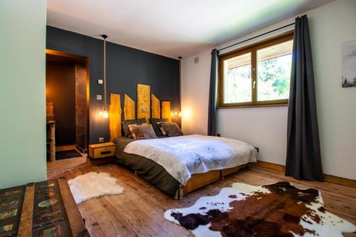 a bedroom with a large bed and a window at Villa - Détente & Jacuzzi aux portes de Gérardmer in Anould