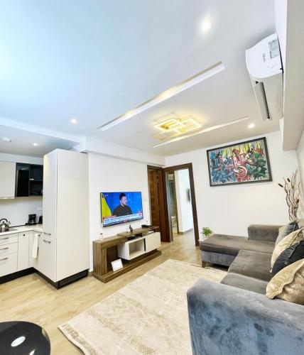 a living room with a couch and a tv at 1 bed Apartment in Osu-Accra in Accra