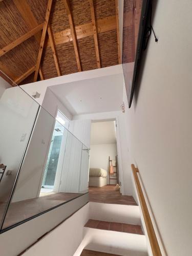 a staircase in a house with a glass wall at Stylish townhouse with gallery in the heart of Tavira for two in Tavira