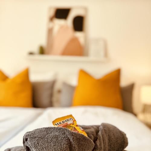 a blanket on a bed with orange pillows at Altstadtglück Seligenstadt in Seligenstadt