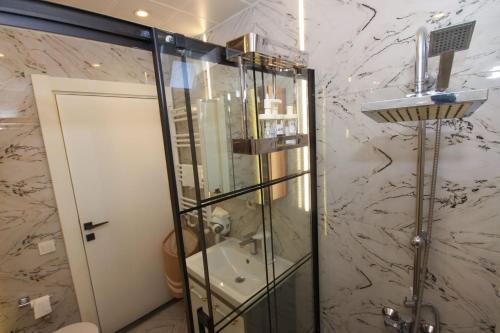 a shower stall in a bathroom with a marble wall at Metropolitan Art in Altınkum