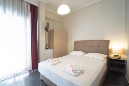 a bedroom with a white bed with towels on it at Hotel Mironi and Victoria in Limenas