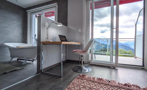 a bathroom with a tub and a desk and a chair at Vermont Hub for Offsites, Retreats & Individual Bookings in Alps in Leysin
