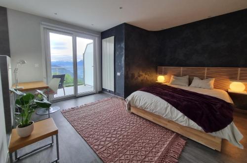 a bedroom with a large bed and a large window at Vermont Hub for Offsites, Retreats & Individual Bookings in Alps in Leysin