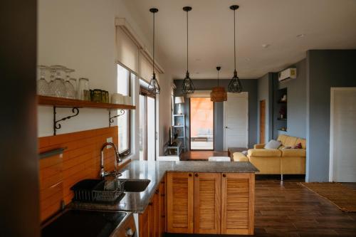 a kitchen with a sink and a living room at El Sitio Penthouse in Playa Venao