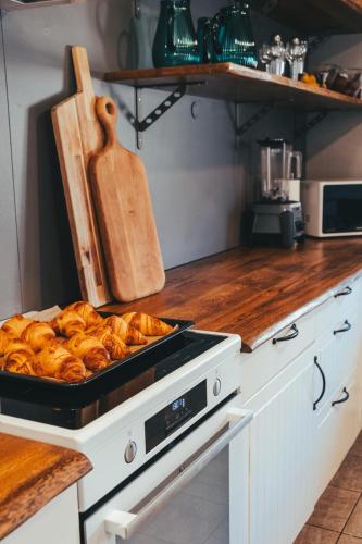a kitchen with a tray of loaves of bread at Hóll Adventure House - Ævintýrahúsið Hóll á Siglufirði in Siglufjörður