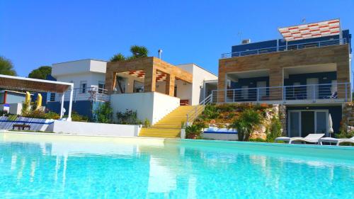 uma villa com piscina em frente a uma casa em Casa Azul em Castellammare del Golfo