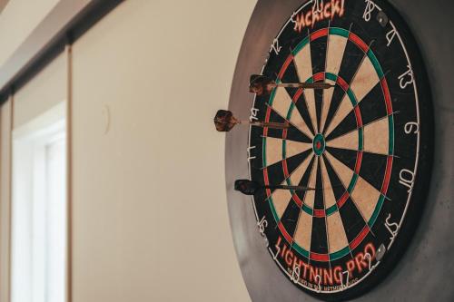 a dartboard hanging on a wall next to a door at Hóll Adventure House - Ævintýrahúsið Hóll á Siglufirði in Siglufjörður
