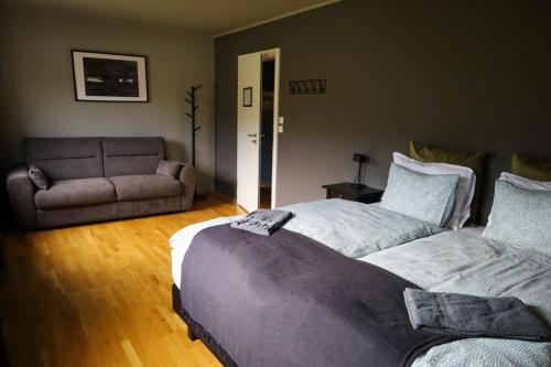a bedroom with a large bed and a couch at Hóll Adventure House - Ævintýrahúsið Hóll á Siglufirði in Siglufjörður