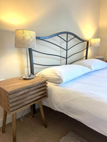 a bedroom with a bed with a lamp on a night stand at Spacious two bedrooms apartment for business and holiday in Portsmouth